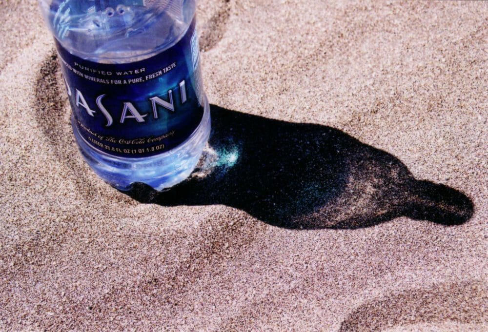 Water bottle in hot sand