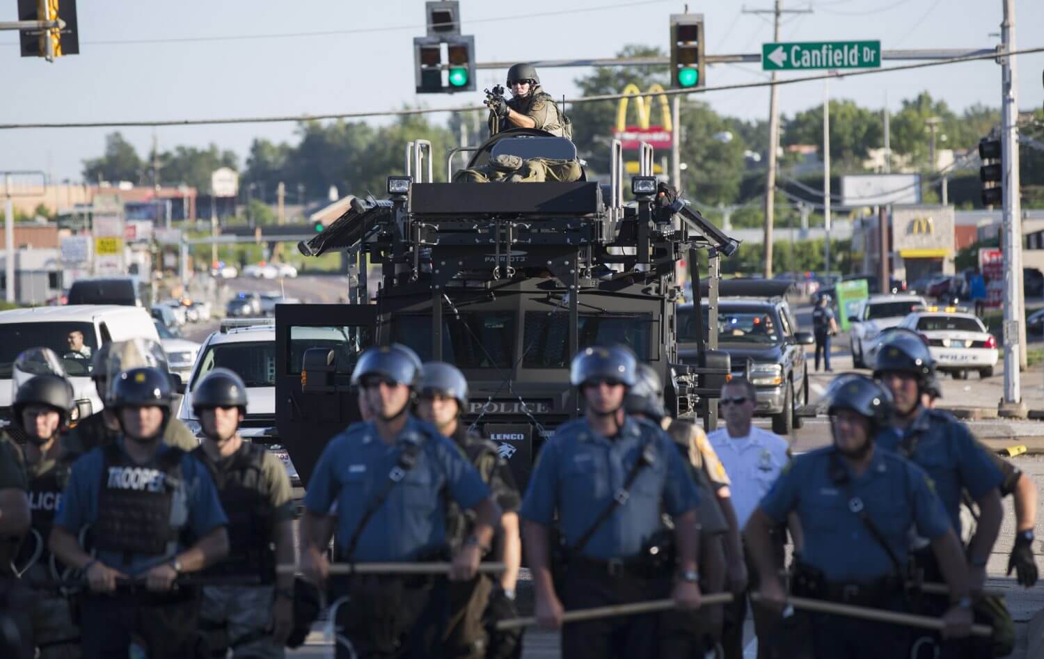Riot police stand guard as demonstrators protest the shooting death of teenager Michael Brown in Ferguson, Missouri