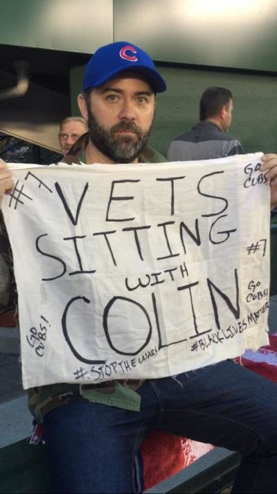 Rory Fanning sitting in solidarity with Colin Kaepernick at a Chicago Cubs baseball game, 2016. / Photo courtesy Rory Fanning