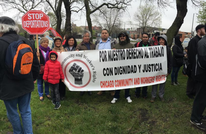 Protestors hold signs that read "Stop Deportations" and "Por Nuestro Derecho al Trabajo Con Dignidad y Justicia, Chicago Community and Workers' Rights.