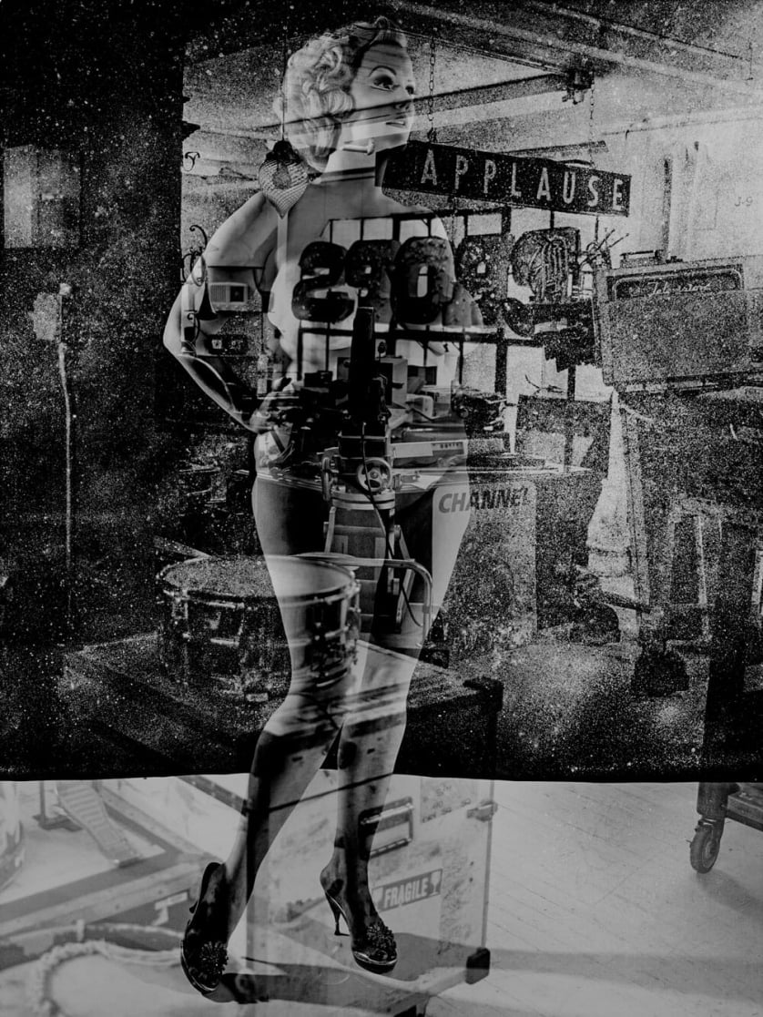 A black-and-white collage in which a voluptuous woman with a 1950s hairstyle is superimposed over various photos of musical instruments and neon signage.