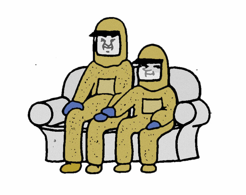 A couple wearing HAZMAT suits sits on the couch. The shorter of the pair has placed their hand on the other’s rubber gloved hand.