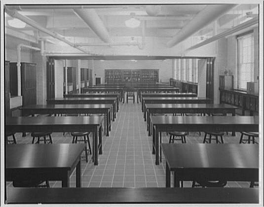 Desks and chairs in an empty 1920s college classroom.