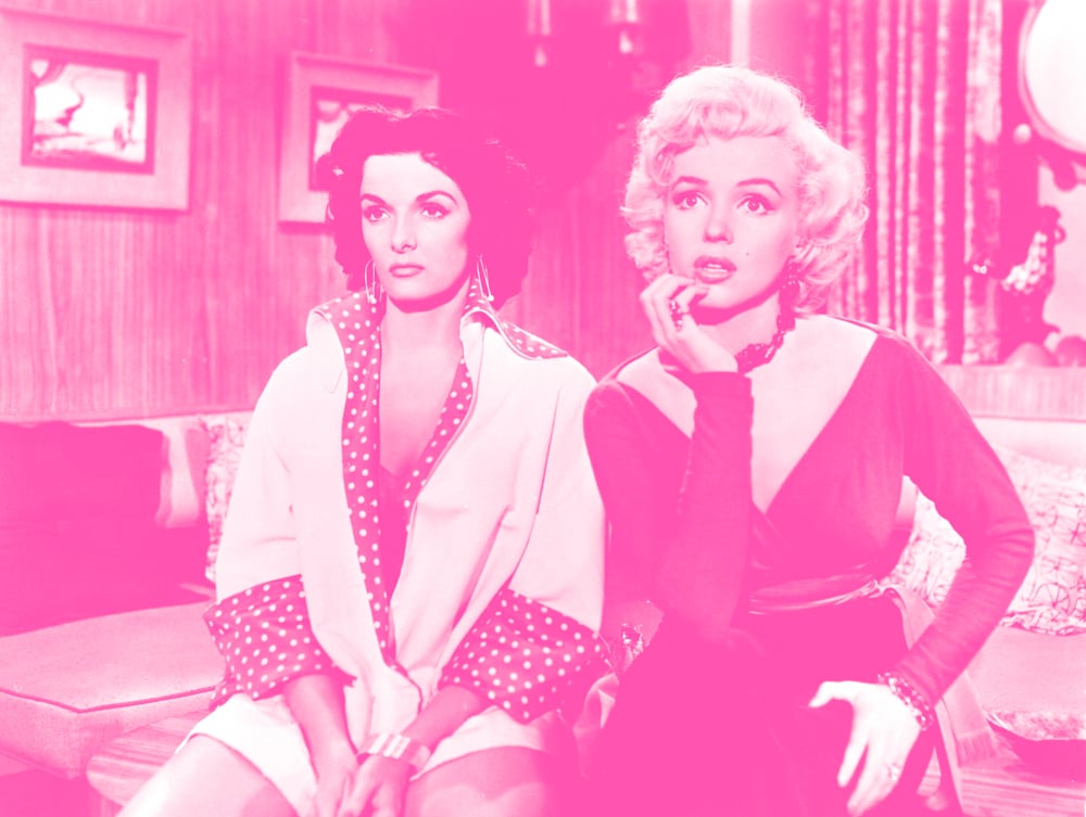 Jane Russell sitting next to Marilyn Monroe.