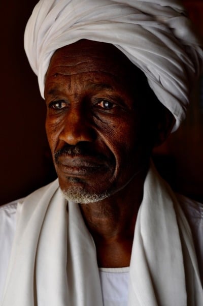 Abderrahim Mohammedu stares to the right of the camera. He's dressed in a white outfit.