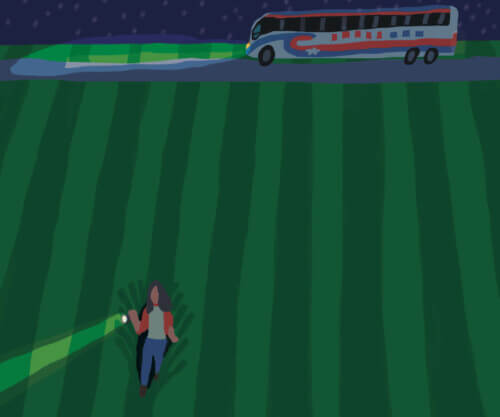 Tour bus is parked on a backcountry road. It’s a dark night and the bus’s headlights are illuminating the field. A woman is walking away from the bus through the field with a flashlight.