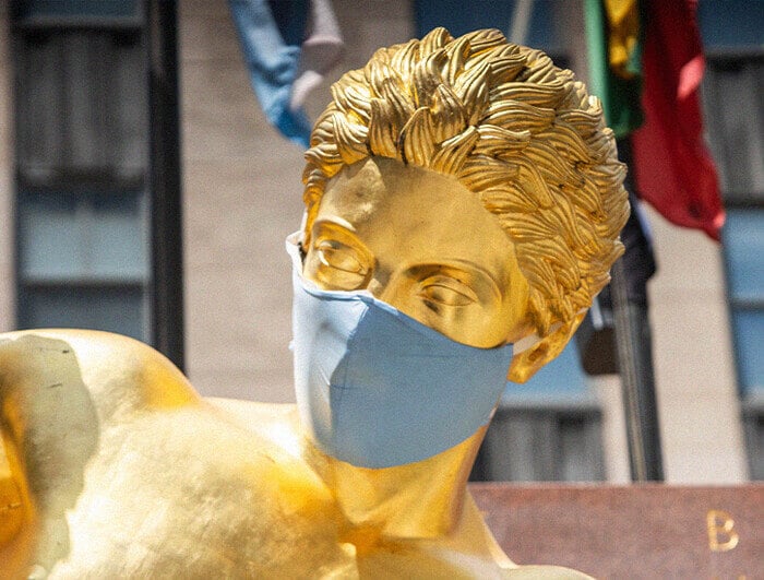 A golden statue wearing a medical face mask.