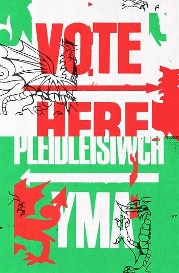 A poster reads “VOTE HERE” on the top and “PLEIDLEISIWCH YMA” on the bottom. Fragmented outlines and silhouettes of a dragon are laid on top of the image. The tone is bold and bright.