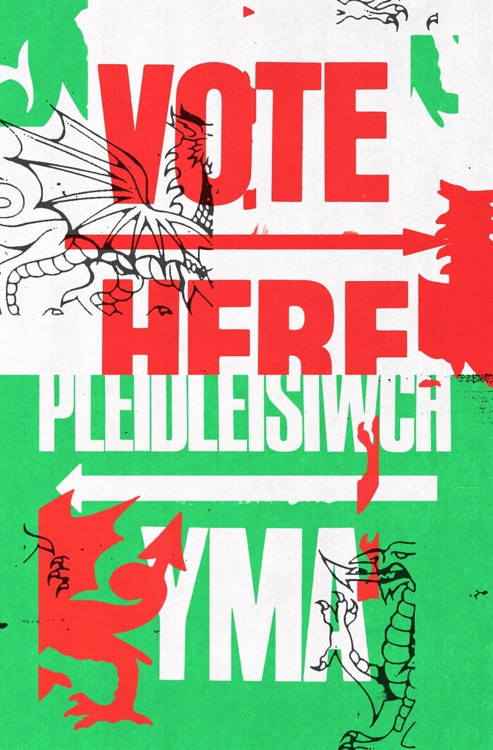 A poster reads “VOTE HERE” on the top and “PLEIDLEISIWCH YMA” on the bottom. Fragmented outlines and silhouettes of a dragon are laid on top of the image. The tone is bold and bright.
