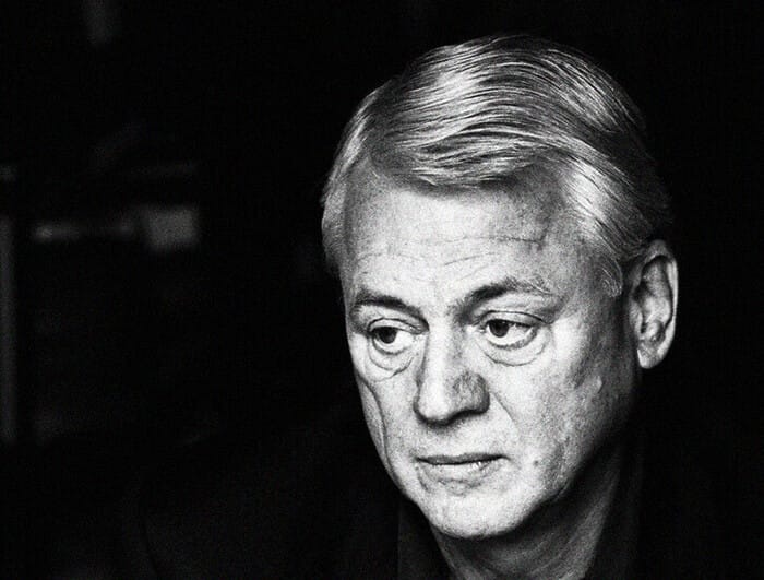 A black and white portrait of Alexander Kluge, looking away from the camera.