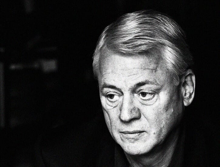 A black and white portrait of Alexander Kluge, looking away from the camera.