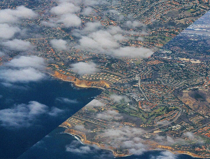 A suburbanized waterfront area show from the air. The image is split in two parallelograms, with one side sliding down.
